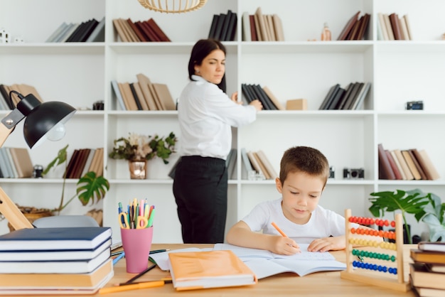 家庭教師は、ラップトップ、実際の家のインテリア、子供時代の概念と学習で未就学児を扱います