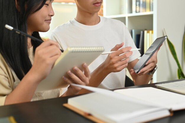 ティーンエイジャーの学生に宿題の学校プロジェクトを支援するデジタルタブレットを持ったチューター 教育と家庭教育の概念