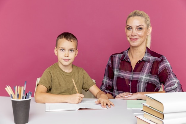 Tutor with child doing homework together in the pink room.