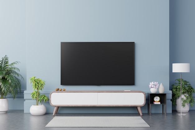 TV on the cabinet in modern living room have plants and book on blue wall background.