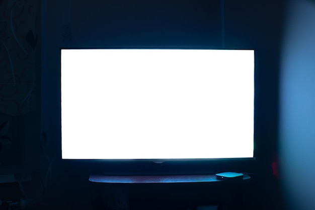 Foto tv in una stanza buia con uno schermo bianco