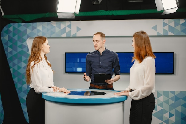 TV game show with two participants answering questions or solving puzzles and host. Smiling women participate in television quiz.