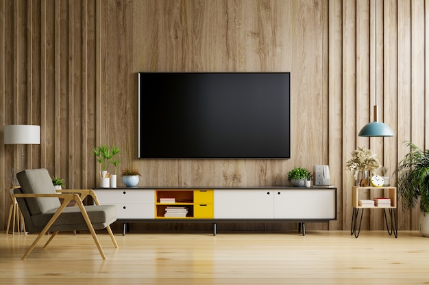 TV op kast in moderne woonkamer met lamp, tafel, bloem en plant op houten muur achtergrond.