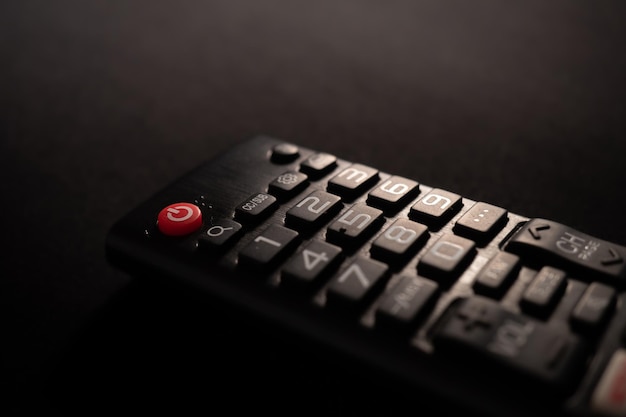 TV power button on the remote control on black background