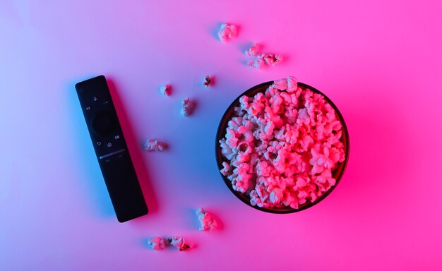 Tv remote and bowl of popcorn.