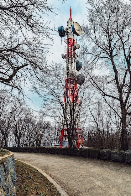 TV-toren naast de asfaltweg, dramatische hemel, bos berg oude landweg met stenen omheining.