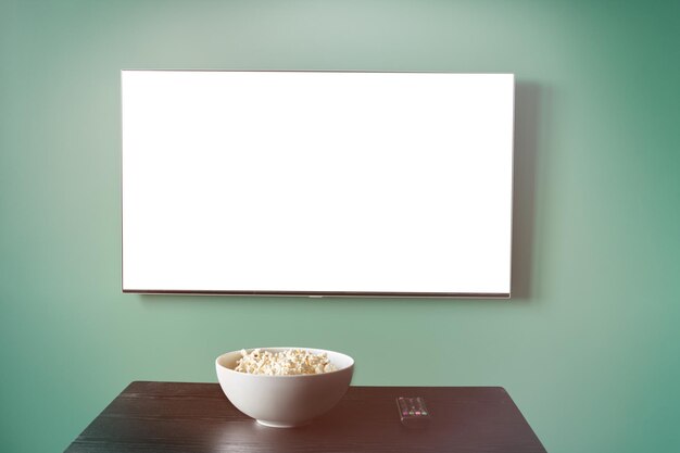 Photo tv white screen with popcorn mockup. online cinema