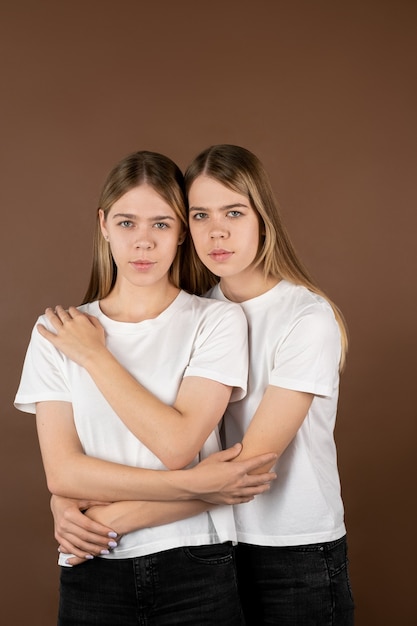 Twee aanhankelijke meisjes in witte t-shirts en zwarte jeans