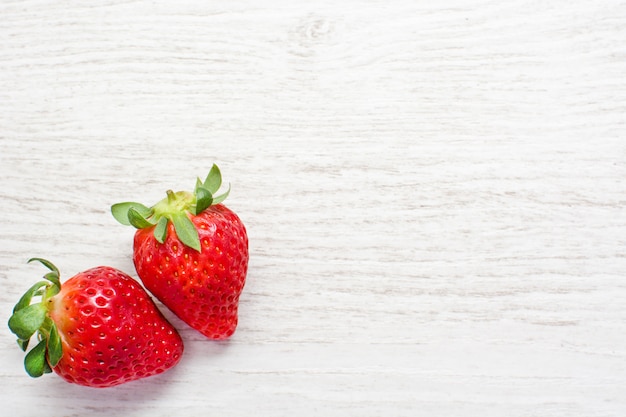 Twee aardbeien op witte houten tafel