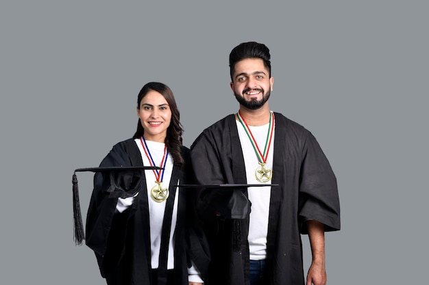 twee afgestudeerde student geïsoleerd op een grijze achtergrond Indiase Pakistaanse model