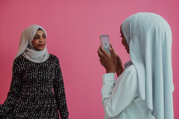 Twee Afro-Amerikaanse vrouwen in hijab poses voor sociale media in de studio. Selectieve aandacht. Hoge kwaliteit foto