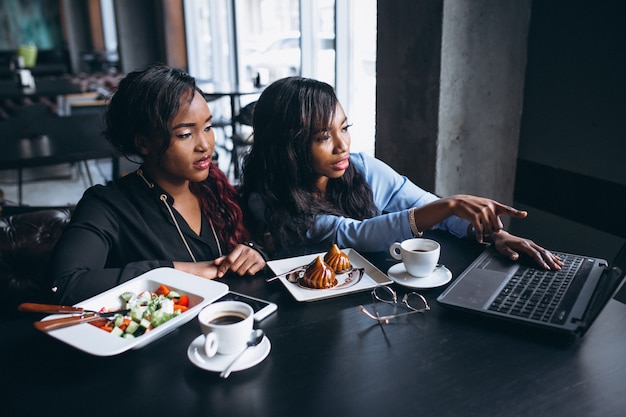 Twee Afro-Amerikaanse vrouwen met laptop en lunch