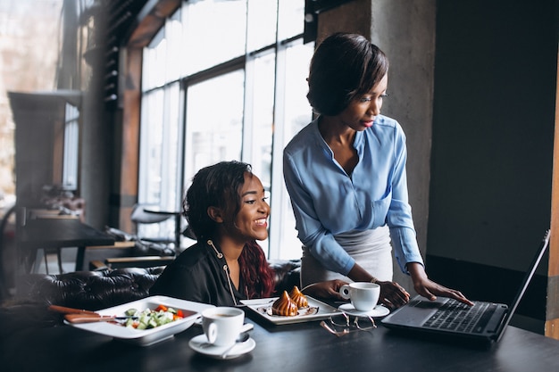 Twee Afro-Amerikaanse vrouwen met laptop en lunch