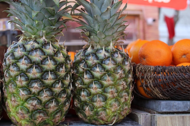 Twee ananassen zitten op een tafel met een bordje met de tekst 'ananas'