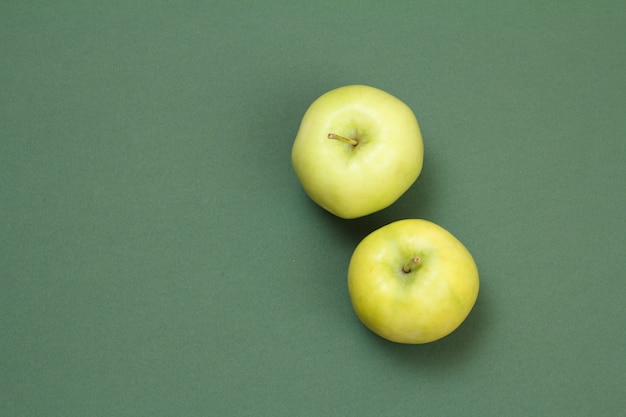 Twee appels op groene achtergrond met kopie ruimte. Bovenaanzicht.