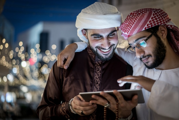 Twee Arabische mannen met tablet in de stad 's nachts