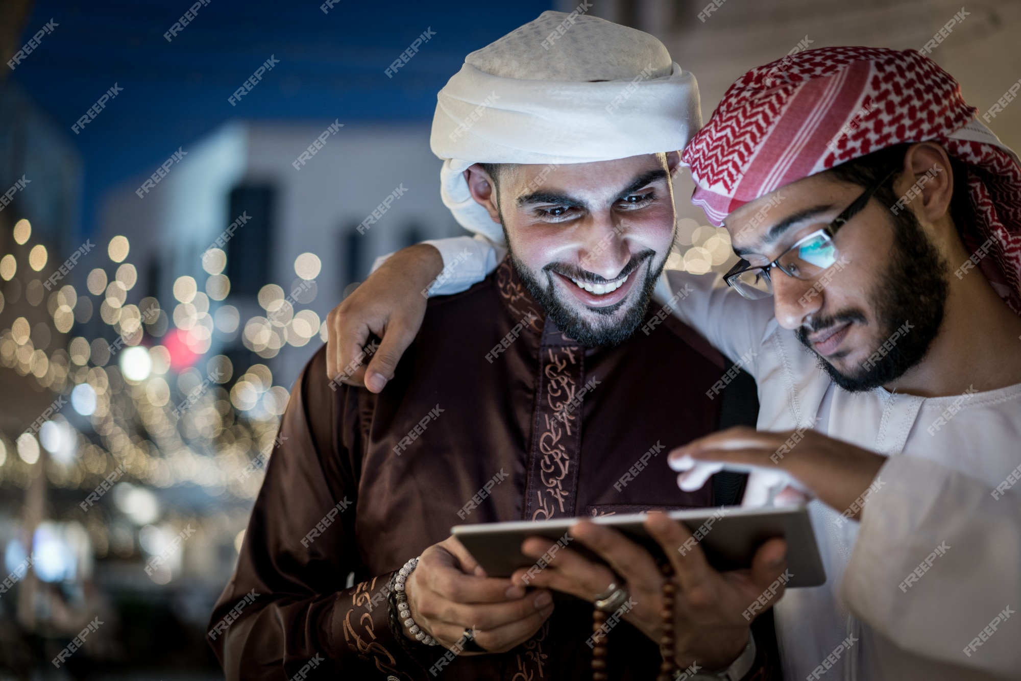 Twee arabische met tablet de nachts | Premium Foto