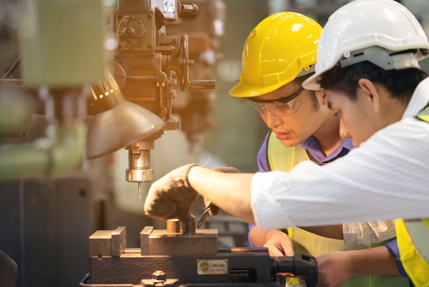 Twee arbeiders in productie-installatie als team bespreken, industriële scène op achtergrond, productieactiviteiten samenwerken