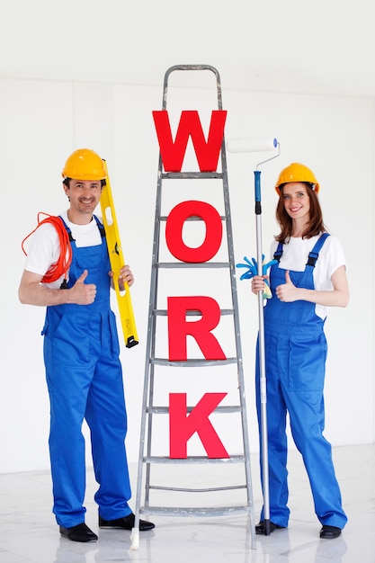 Twee arbeiders voor ladder met woordwerk