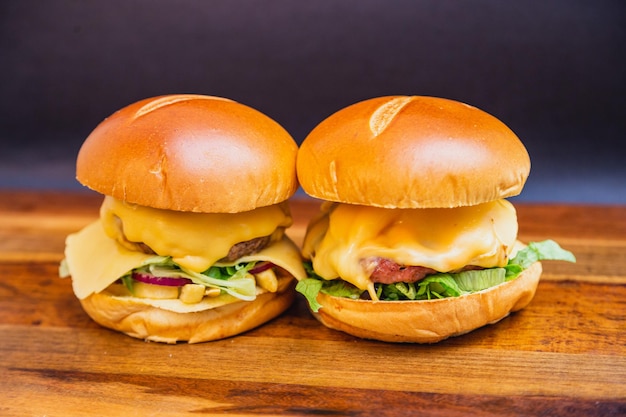 Twee artisanale burgers gemaakt met geroosterde worst uienringen en tomaat en uiensalade Vinaigrette