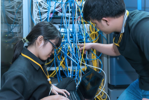 Twee Aziatische ingenieurs die in de serverruimte werkenControleer de verbindingsproblemen van computernetwerkenThailand mensen