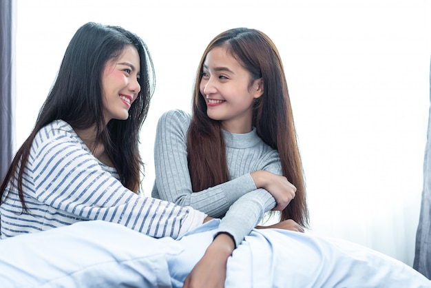 Twee Aziatische Lesbische vrouwen die samen in slaapkamer kijken. Paar mensen en schoonheid concept