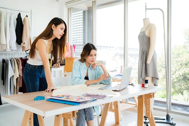 Twee Aziatische vrouwelijke modeontwerpers of kleermakers brainstormden en bespraken de ontwerpcollectie