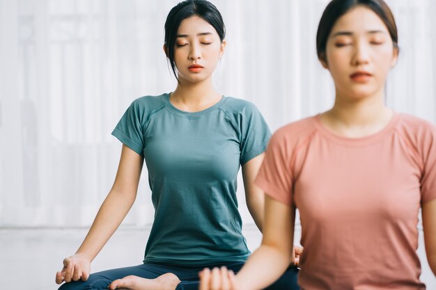 Twee Aziatische vrouwen beoefenen thuis meditatie