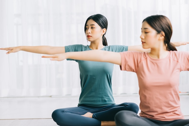 Twee Aziatische vrouwen beoefenen thuis meditatie