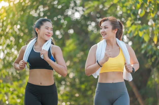 Twee Aziatische vrouwen joggen en sporten in het park