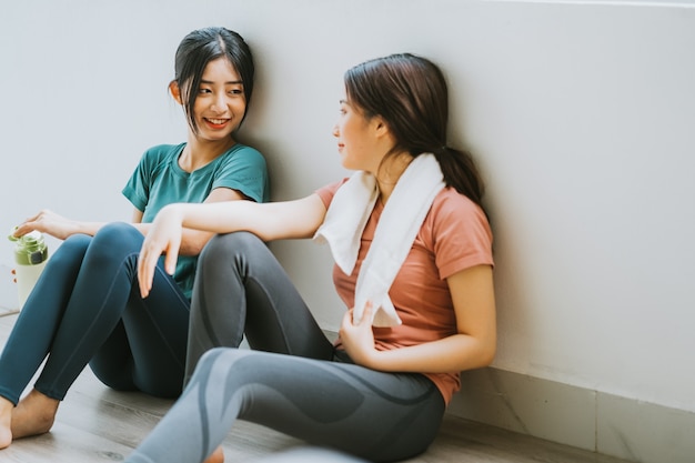 Twee Aziatische vrouwen nemen een pauze van yogasessie