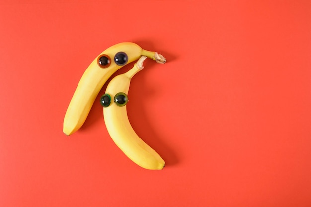 Twee bananengezichten met ogen vrolijke gezichten gemaakt van plastic poppenogen en verse gele bananen