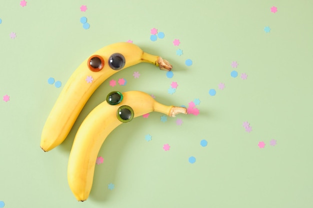 Twee bananengezichten met ogen vrolijke gezichten gemaakt van plastic poppenogen en verse gele bananen