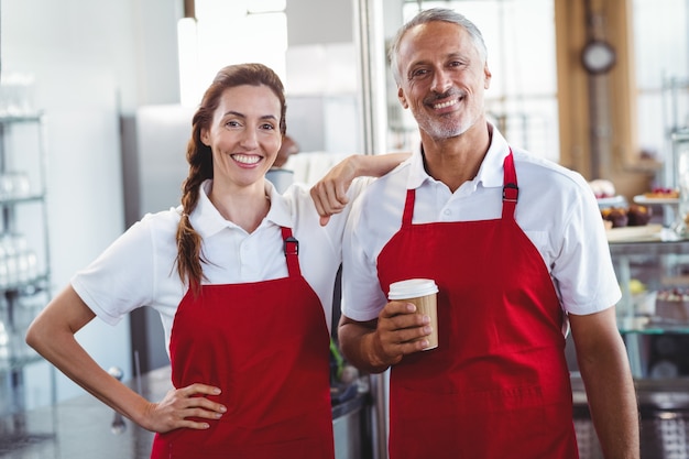 Twee barista&#39;s die bij de camera glimlachen