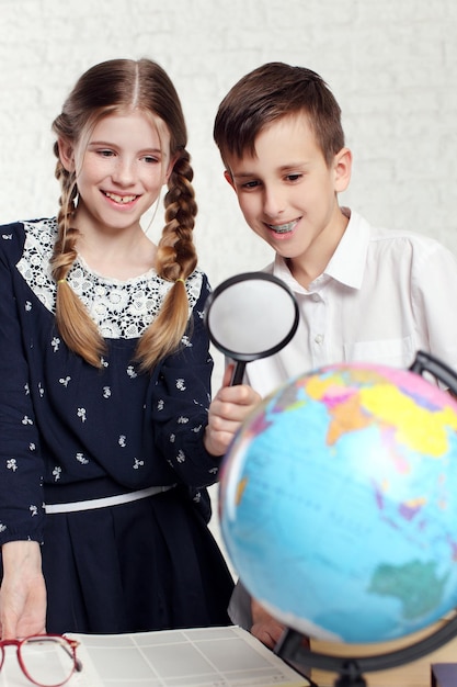 Twee basisschoolleerlingen kijken naar globe