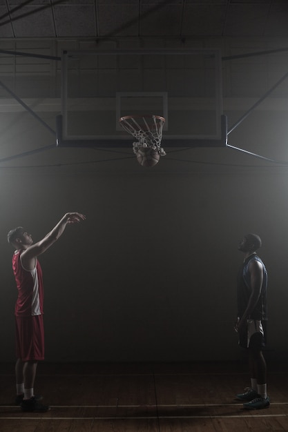 Twee basketbalspeler met een scoren van een shoot