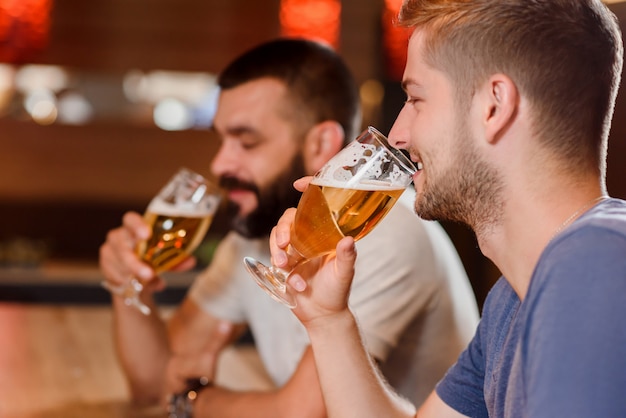 Twee bebaarde mannen bier drinken in café.