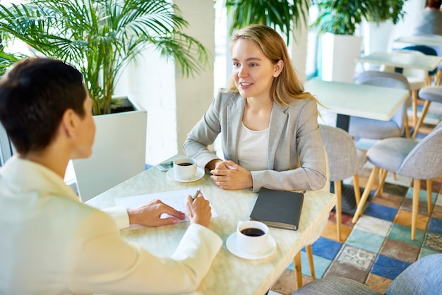 Twee Bedrijfsvrouwen die bij Koffiepauze samenkomen