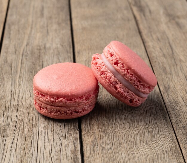 Twee bessen macarons gestapeld over houten tafel.