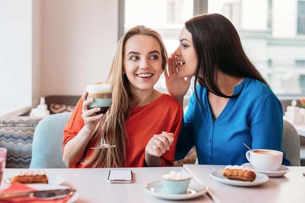 Twee beste vrienden die in café zitten, genieten van een gesprek en nieuws delen