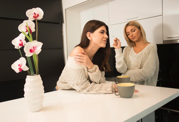 twee beste vriendinnen die koffie drinken in de keuken. vrienden concept