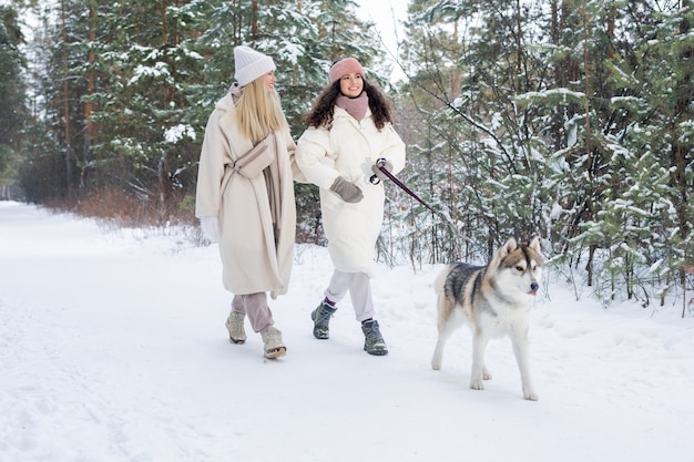 Twee blanke meisjes wandelende hond