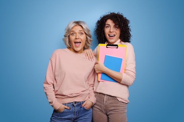 Twee blanke vrouwen worden voorbereid op studies met de nodige boeken portret van verbaasd meisje...