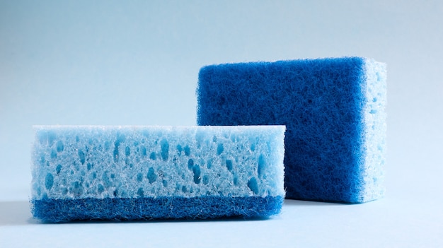 Twee blauwe sponzen die worden gebruikt voor het wassen en wissen van vuil dat door huisvrouwen in het dagelijks leven wordt gebruikt. Ze zijn gemaakt van poreus materiaal zoals schuim. Wasmiddelretentie, waardoor u het economisch kunt besteden.