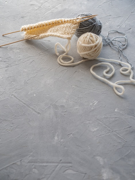 Twee bollen wol en een sjaal breien met houten spaken. Het concept van handwerk, handgemaakt.