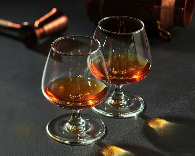 Twee borrels met cognac op donkergrijze stenen aanrecht