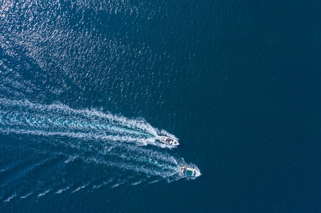 Twee boten drijvend op de zee met hoge snelheid drone weergave.