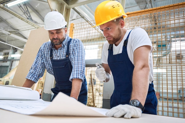 Twee bouwvakkers inspecteren plannen