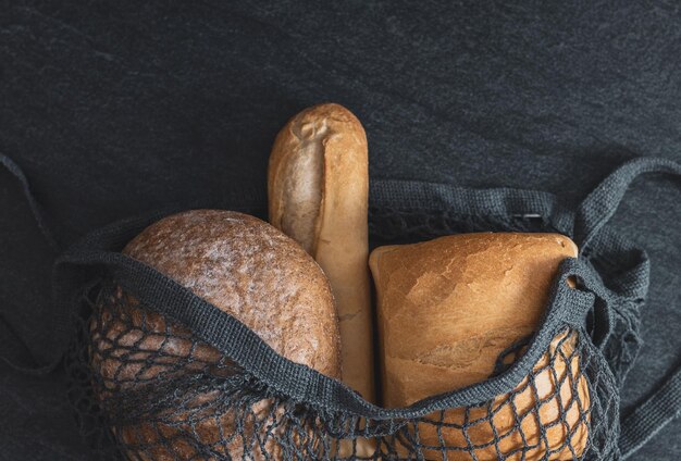 Twee broden en een stokbrood in een rooster op tafel