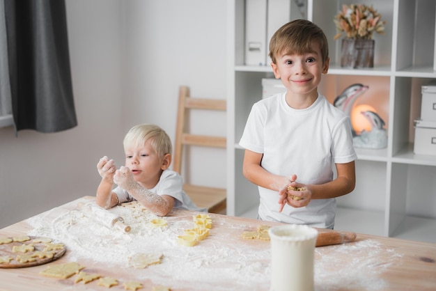 Twee broers maken zelfgemaakte koekjes De hele keukentafel staat in de bloem